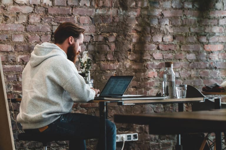 man working on his laptop at a coffee shop