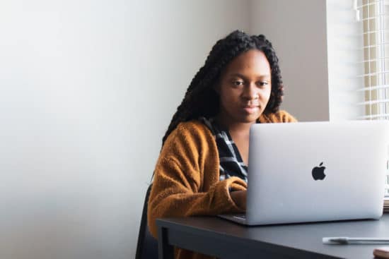 woman typing on a macbook